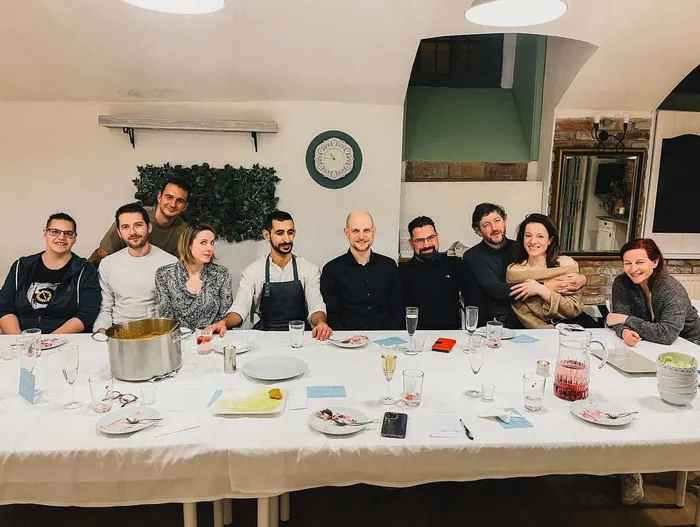 Vendégek egy hosszú vacsoraasztal körül