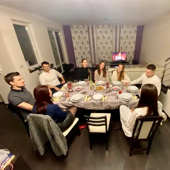 Tizenkét vendég egy hosszú asztalnál egy lakásvacsorán